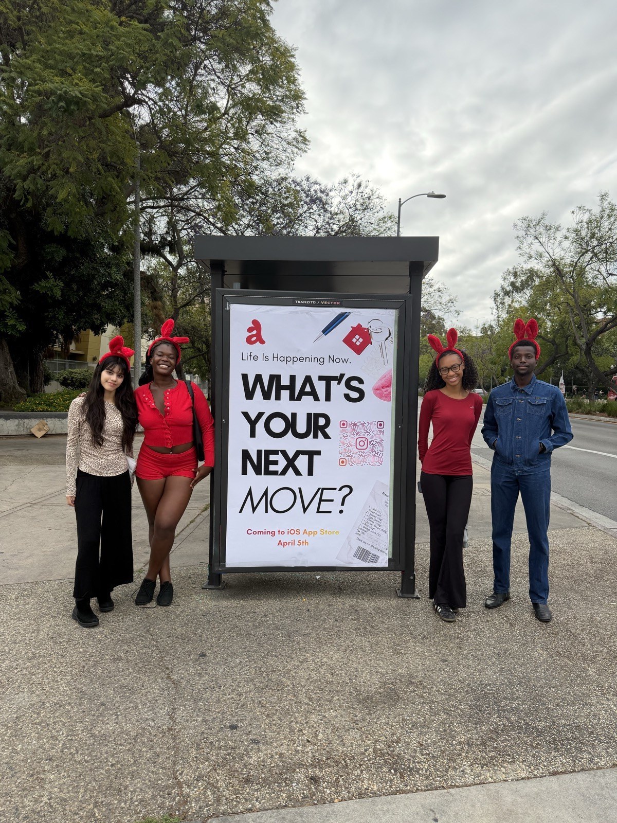 The Addison team beside the bus-stop ad